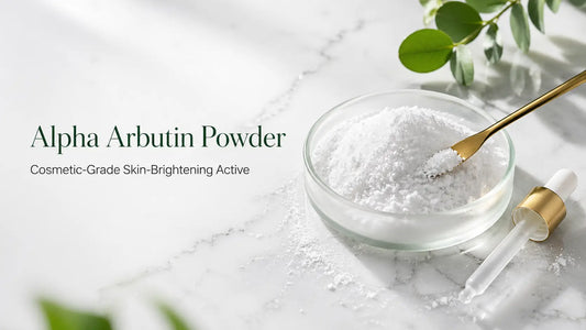 Fine white Alpha Arbutin powder in a frosted-glass petri dish on a white marble surface, Bio Shop Pakistan ingredient glossary.