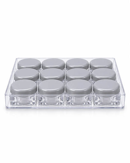 12 empty 10gm clear square lip balm jars with purple screw lids arranged in a transparent storage tray