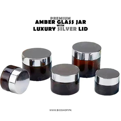 Set of premium amber glass jars with silver lids on a white background