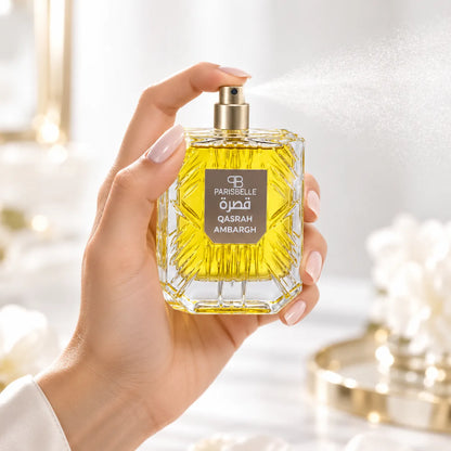 Parisbelle Qasrah Ambargh perfume with golden-yellow liquid visible through its presentation box